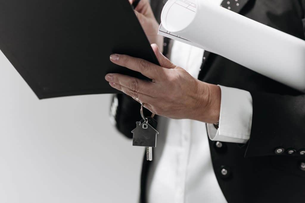 Profesional con la escritura de una vivienda y las llaves en la mano
