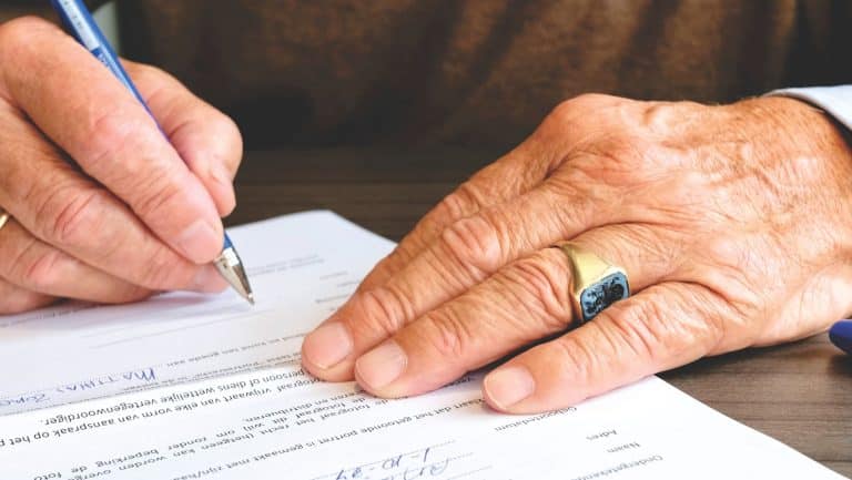 Manos firmando un documento ante notario